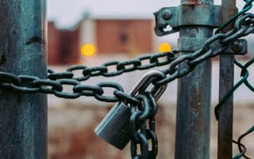 A gate being locked together by chains and a padlock